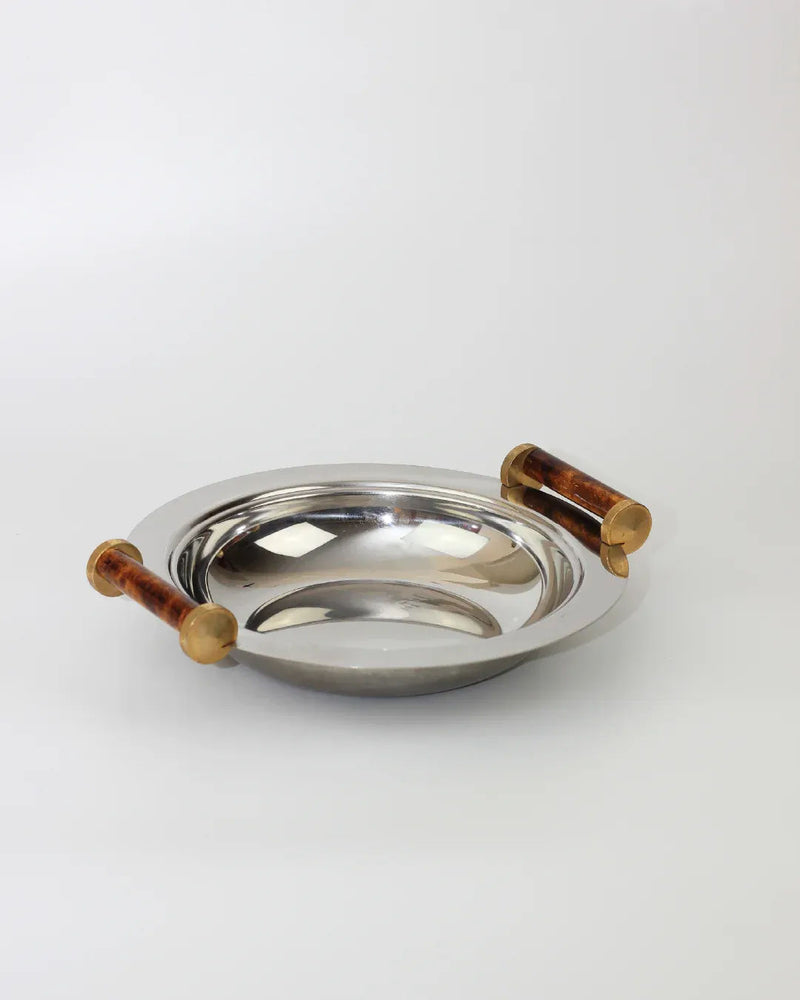 The Boga Avante Shop's Stainless Steel Art-Deco Bowl features an elegant round silver dish with stylish elevated brown and gold enameled handles, set beautifully against a light gray background.