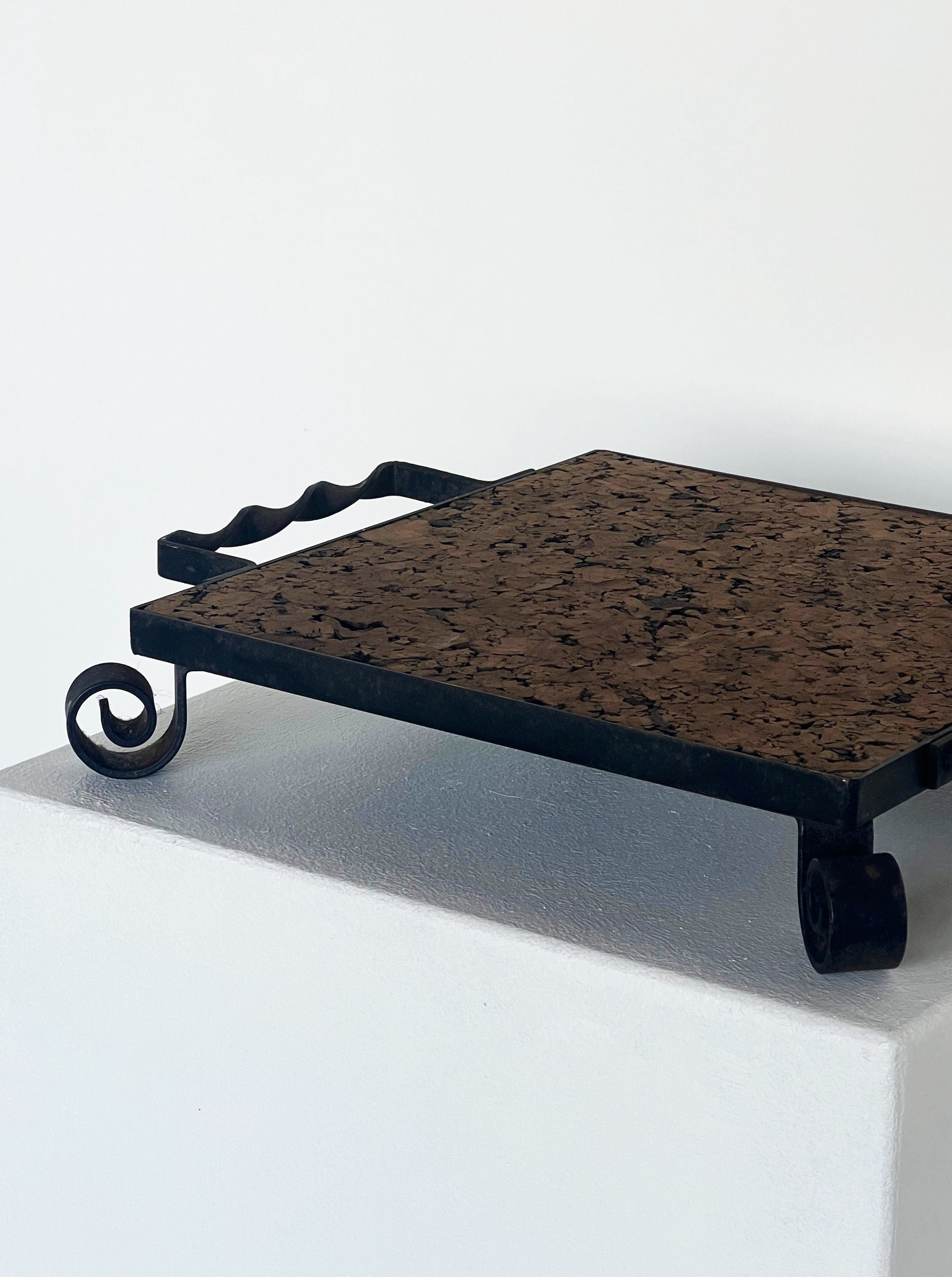 Decorative cork and cast iron display plate featuring intricate scrollwork and natural cork surface