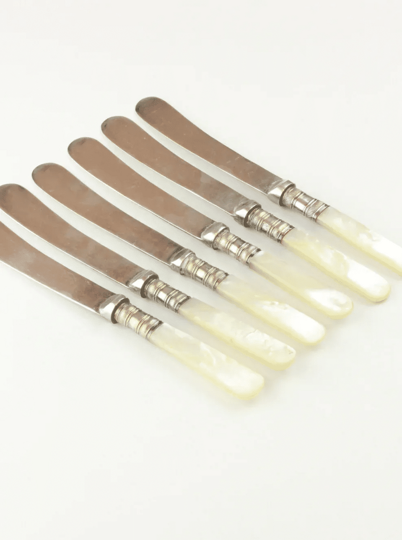 Five pieces of Boga Avante Shop's Mother of Pearl Knives arranged in a fan-like pattern, lying on a plain white background.
