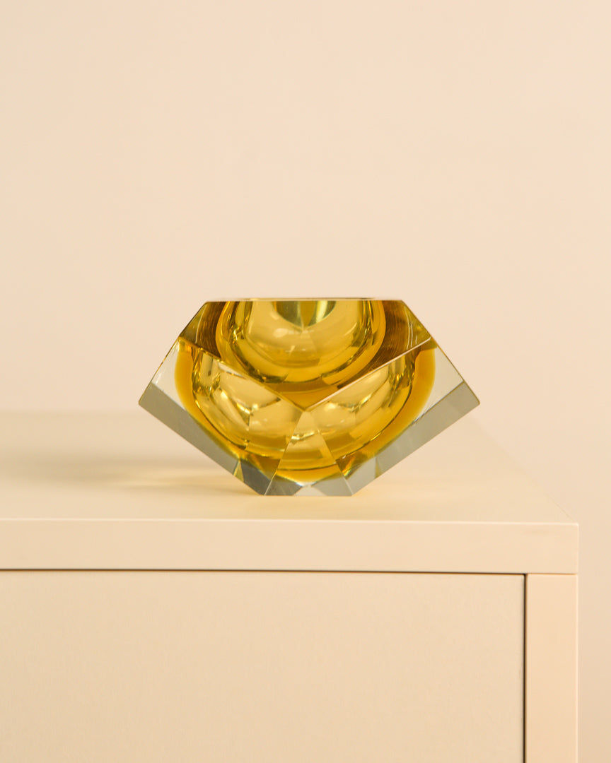 Yellow Murano glass diamond vide-poche on cream cabinet surface
