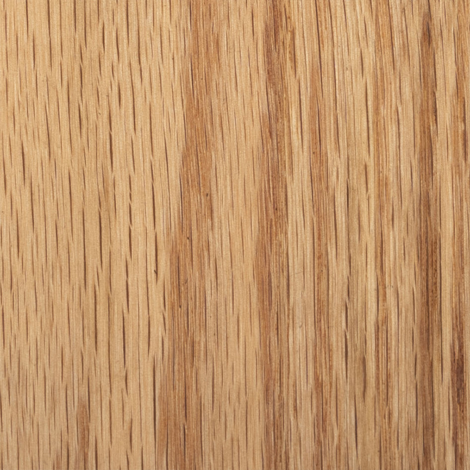 A close-up of a wooden surface with natural grain mirrors the solid oak frame of the Marina Sofa by ASERIES OF OBSTACLES, SL. The warm, light brown wood features visible vertical darker lines, showcasing its texture.