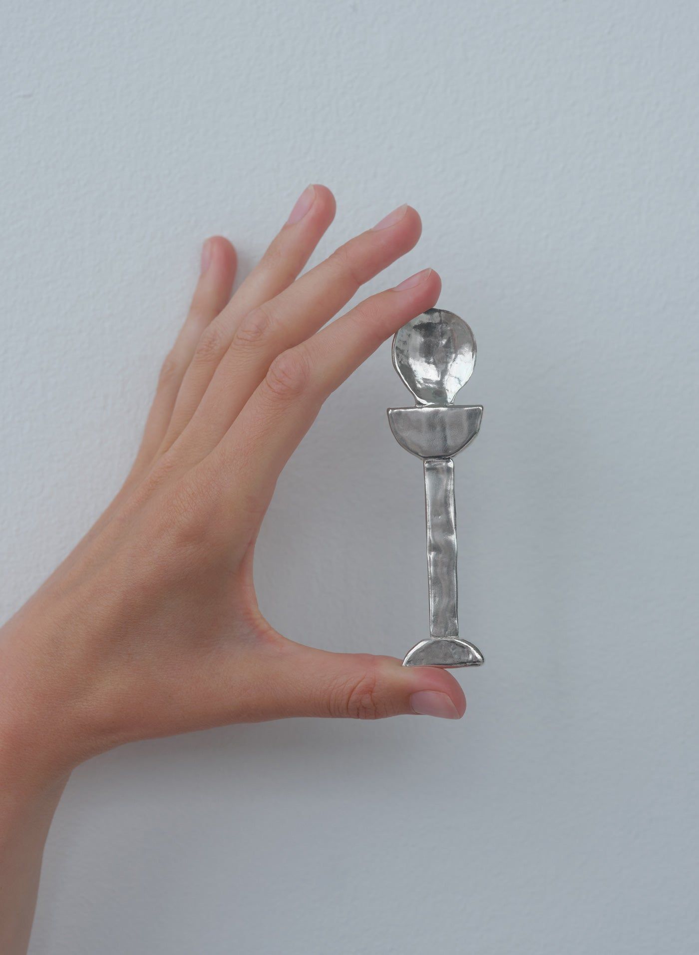 Hand displaying clear crystal Lee spoon with geometric design segments