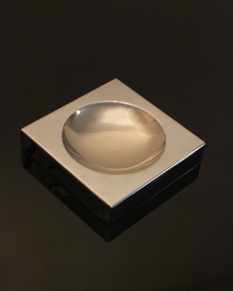 Sleek metallic space age vide-poche with circular depression