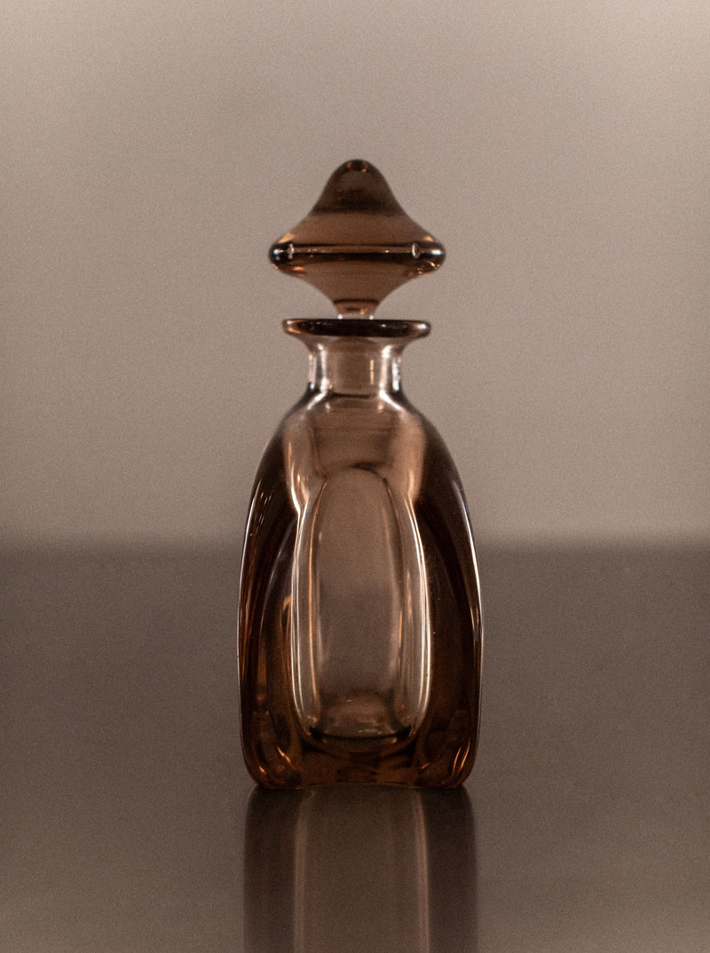 Elegant hand-blown glass decanter with curved handle and gold accents
