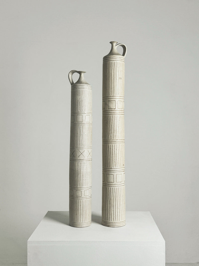 Two tall ceramic column bottles by Bruno Gambone with geometric patterns