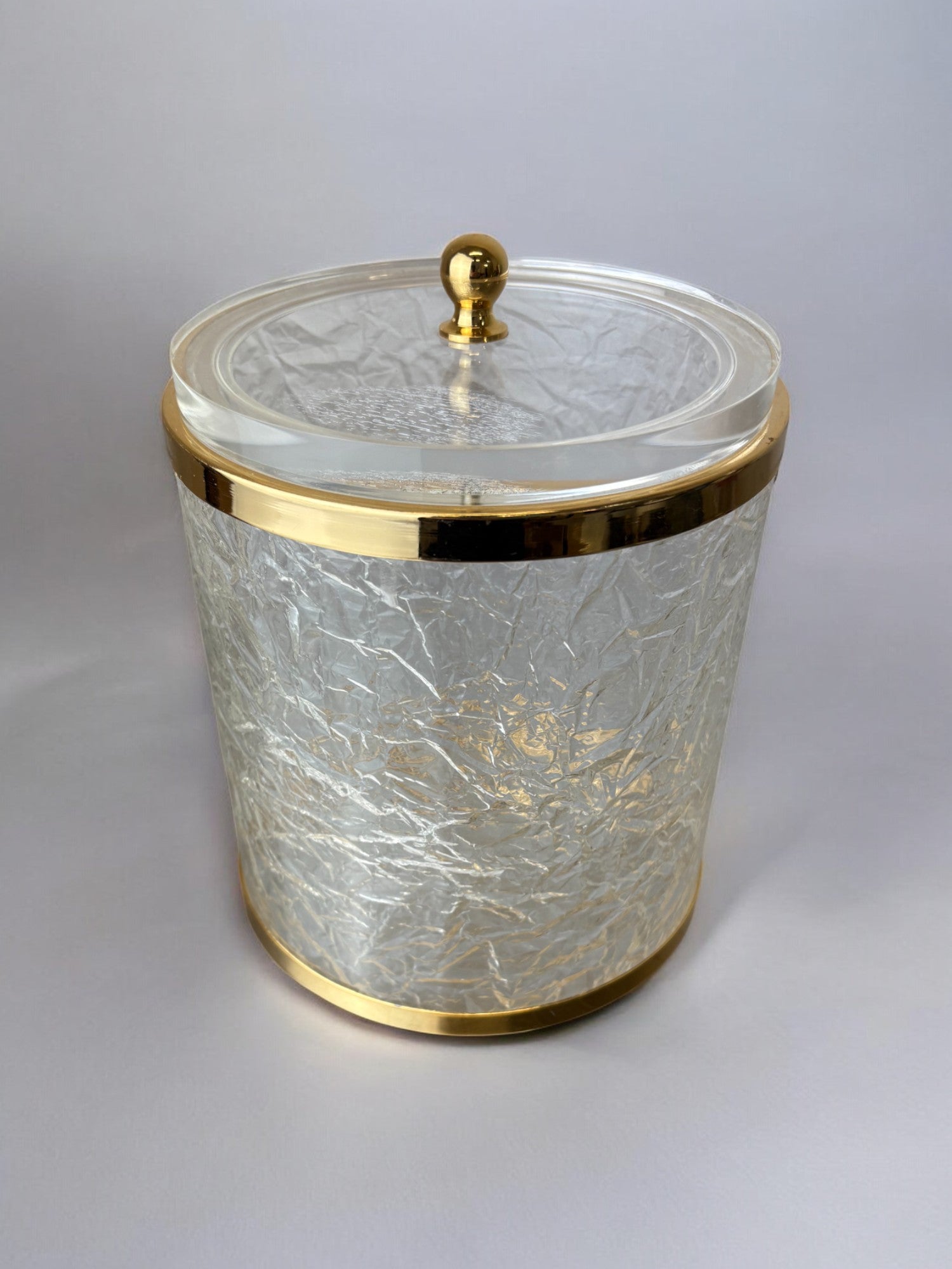 Clear lucite ice bucket with gold trim and textured surface detail