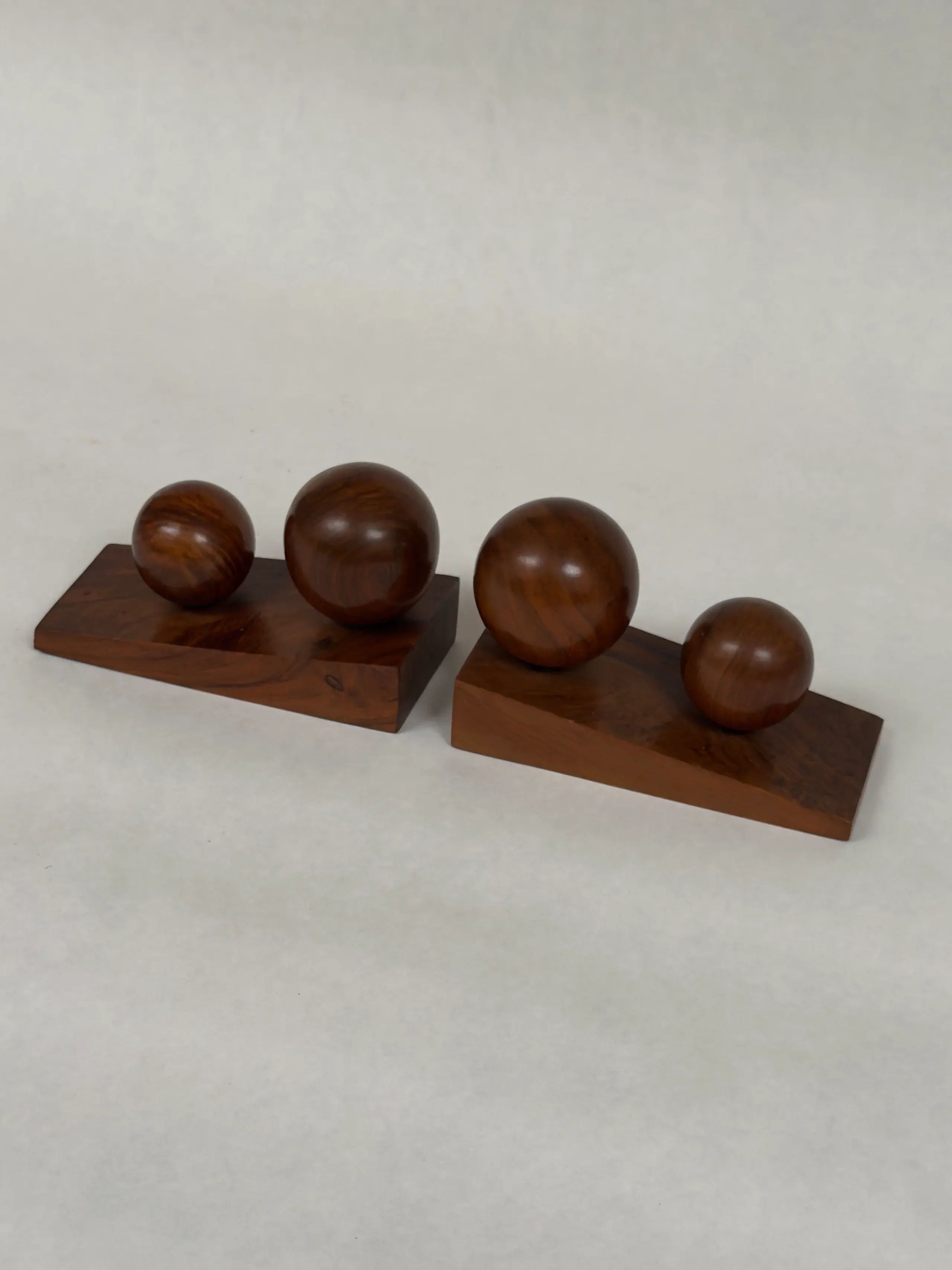 Galerie Storm's Art Deco Bookends in Walnut feature two sculptures with three polished spheres of descending size on rectangular wooden bases, all set against a plain, light background.