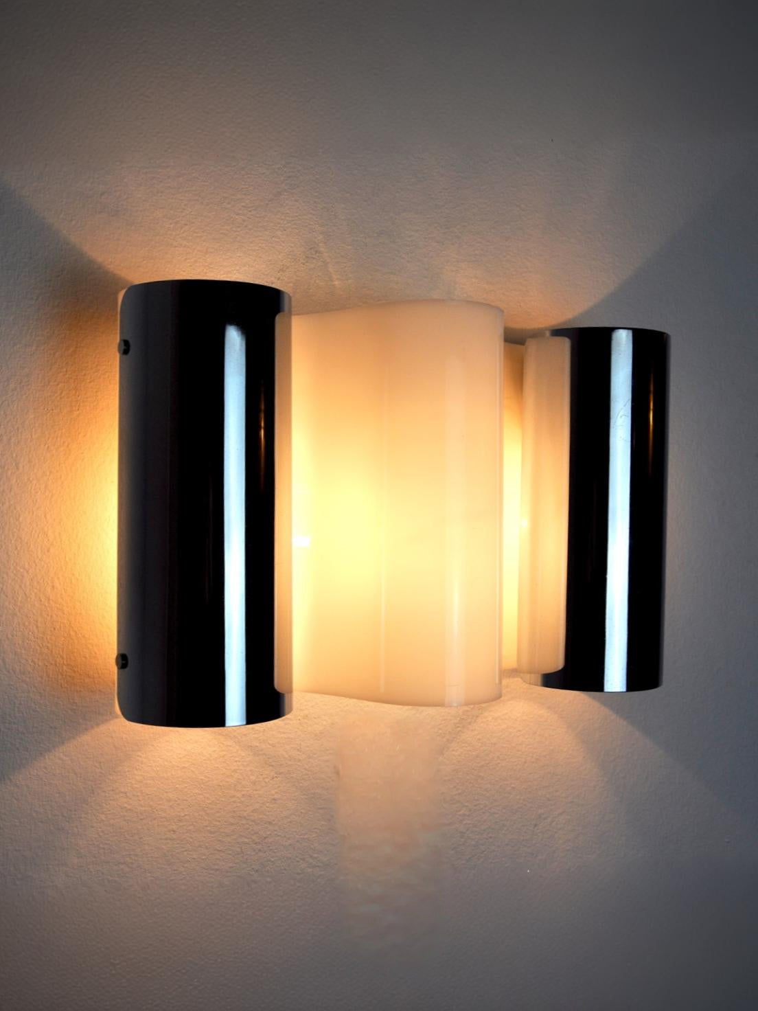 Metalarte Wave sconce illuminated showing chrome and glass detail