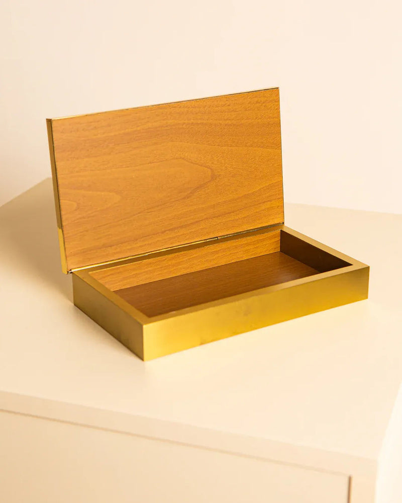 The Italian Box by Bicchielli 80's, from Treaptyque, is open on a light surface. This small, wooden, hinged-lid storage box has an elegant golden hue highlighting its 1980s design charm and craftsmanship. Inside, the box is empty.