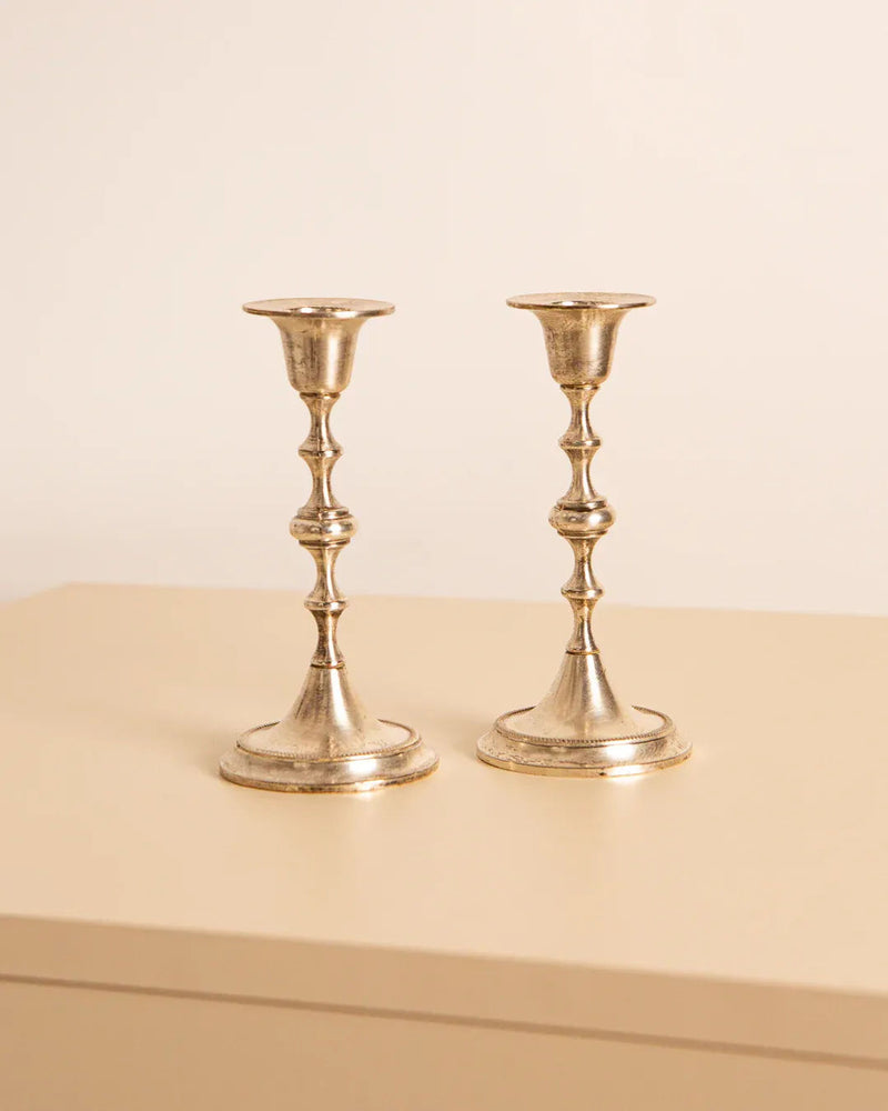 The Pair of Silver Candleholders 60's by Treaptyque grace a light-colored surface against a plain background, exuding the elegance of 1960s Italy with their classic, slender design featuring circular bases and holders for taper candles.