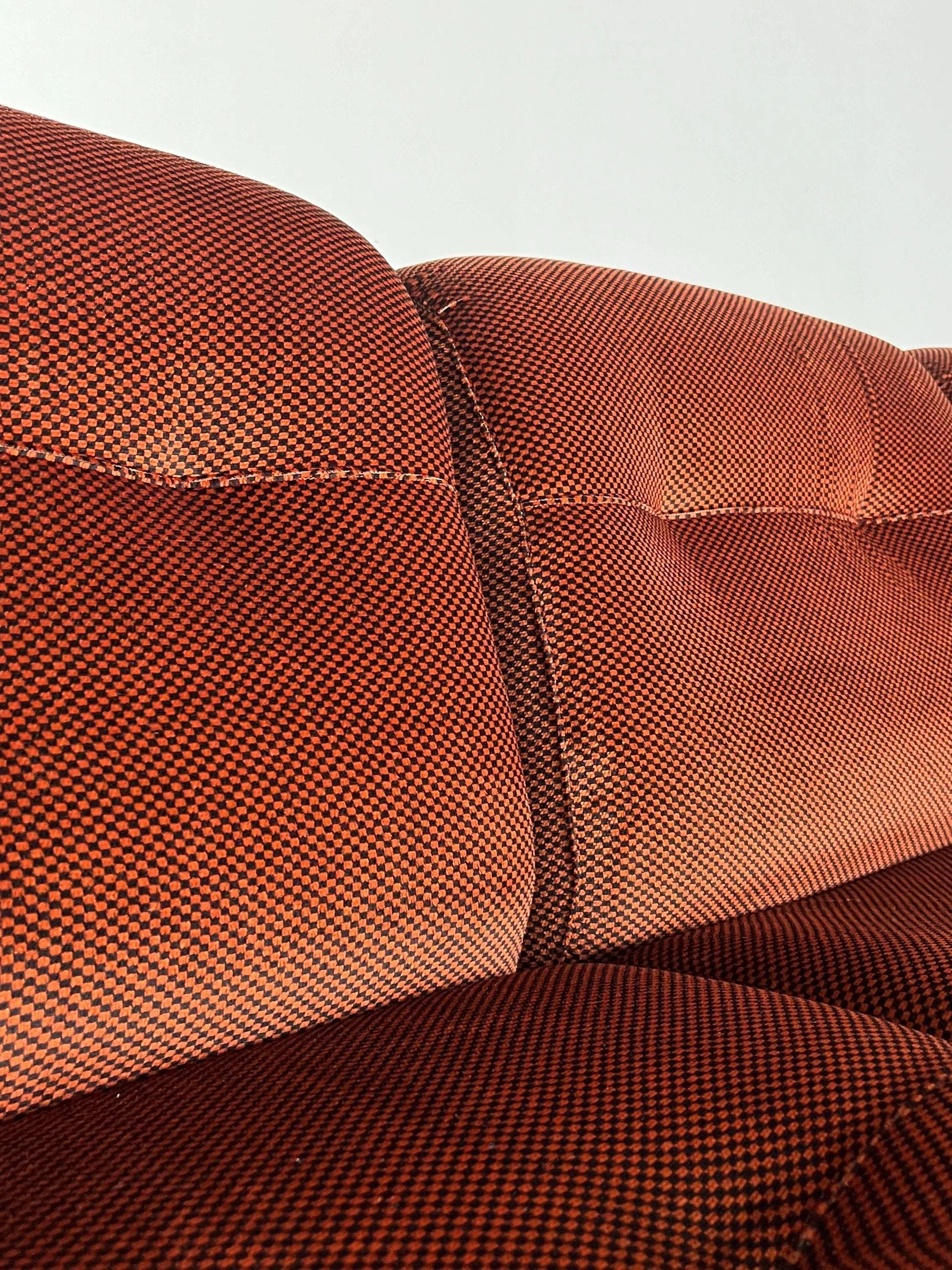 Close-up of the Italian Space Age Seating Set by Cherry Cargo from the 1970s, featuring orange and black checkered upholstery. The intricate stitching and velvet-like texture blend modern design with timeless elegance.