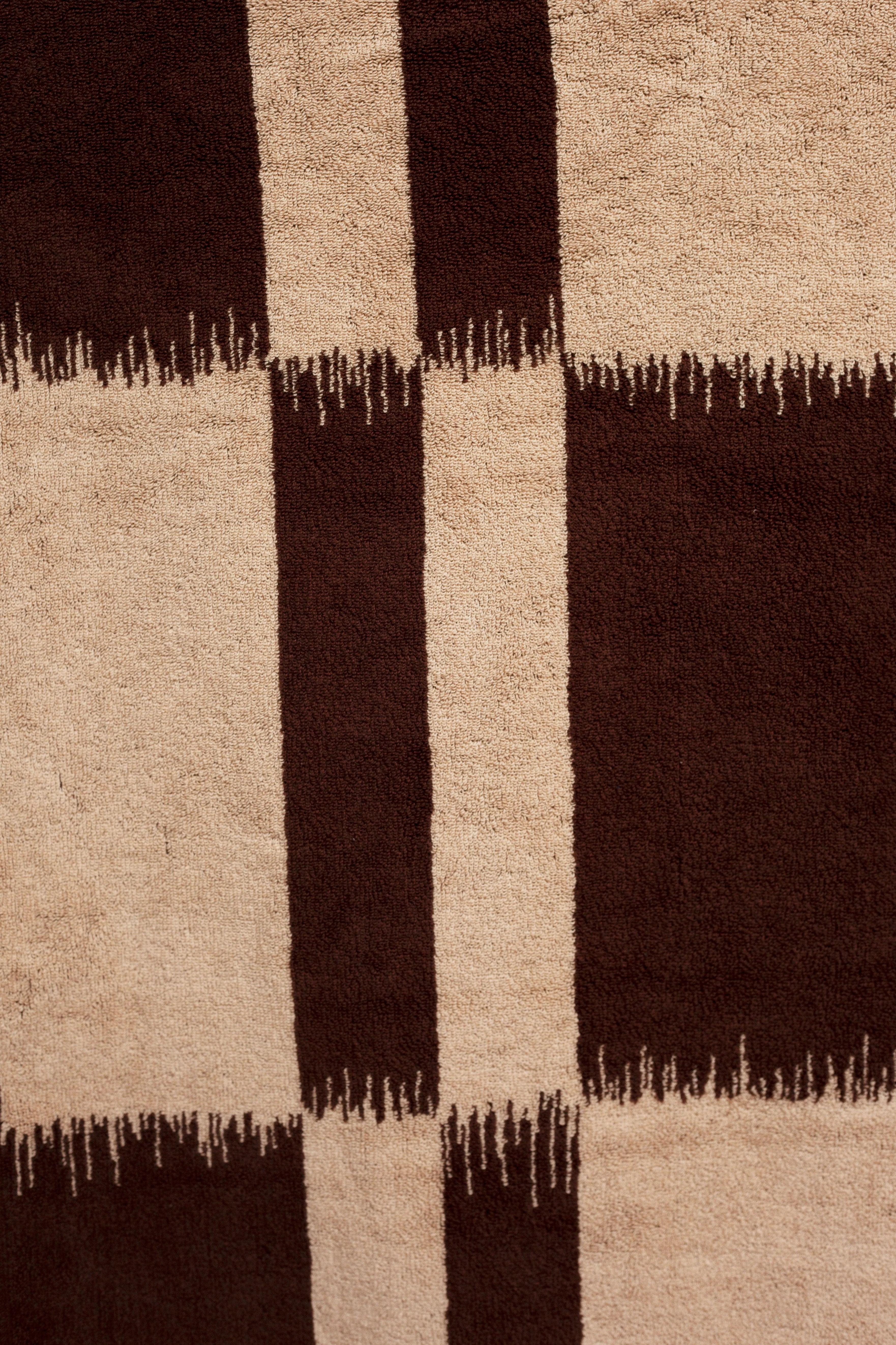 Close-up of a textured rug featuring alternating vertical stripes in shades of brown and beige with rough, fringe-like edges blending the colors using Ikat weaving techniques by Autumn Sonata.