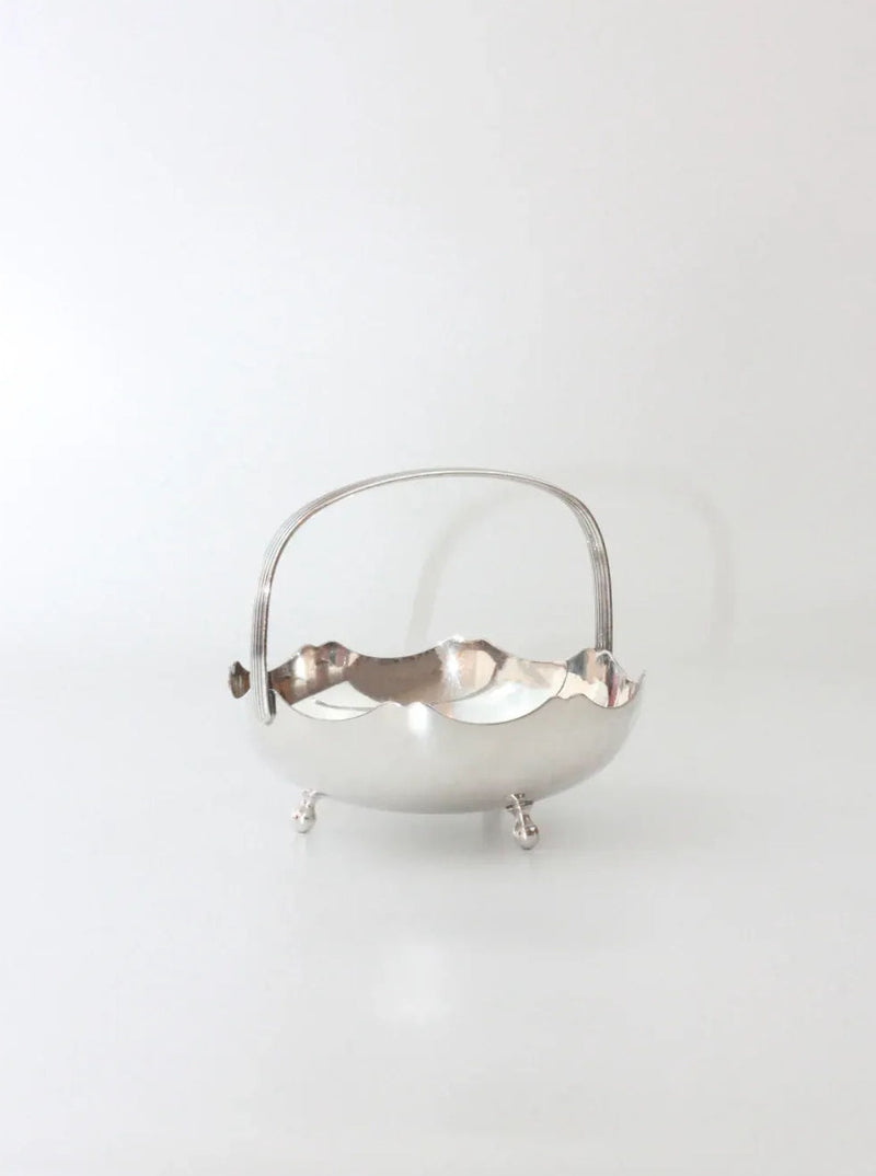 A silver vintage basket with intricate floral and vine pattern details