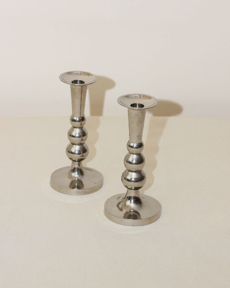 Two polished silver Acero candleholders with bulbous stems