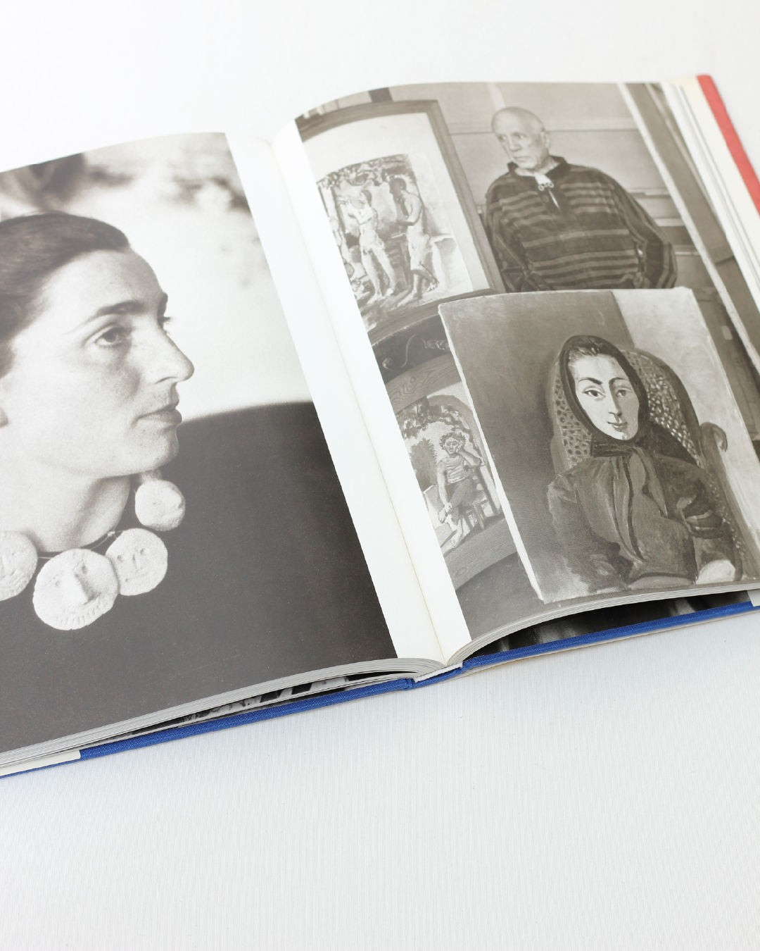 The Boga Avante Shop’s "Picasso and Jacqueline" shows an open book: the left page depicts a Jacqueline-like woman with a chunky necklace; the right shows a man among portraits, recalling scenes from Picasso's era.