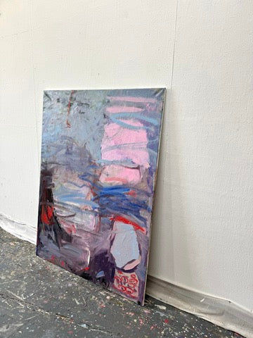 An abstract oil painting, "About Undine" by Petra Schott, rests against a white wall. Its textured canvas, drenched in purples, pinks, blues, and reds, evokes a mermaid myth while scattered paint marks on the dark floor below hint at tales of Undine Leaves.