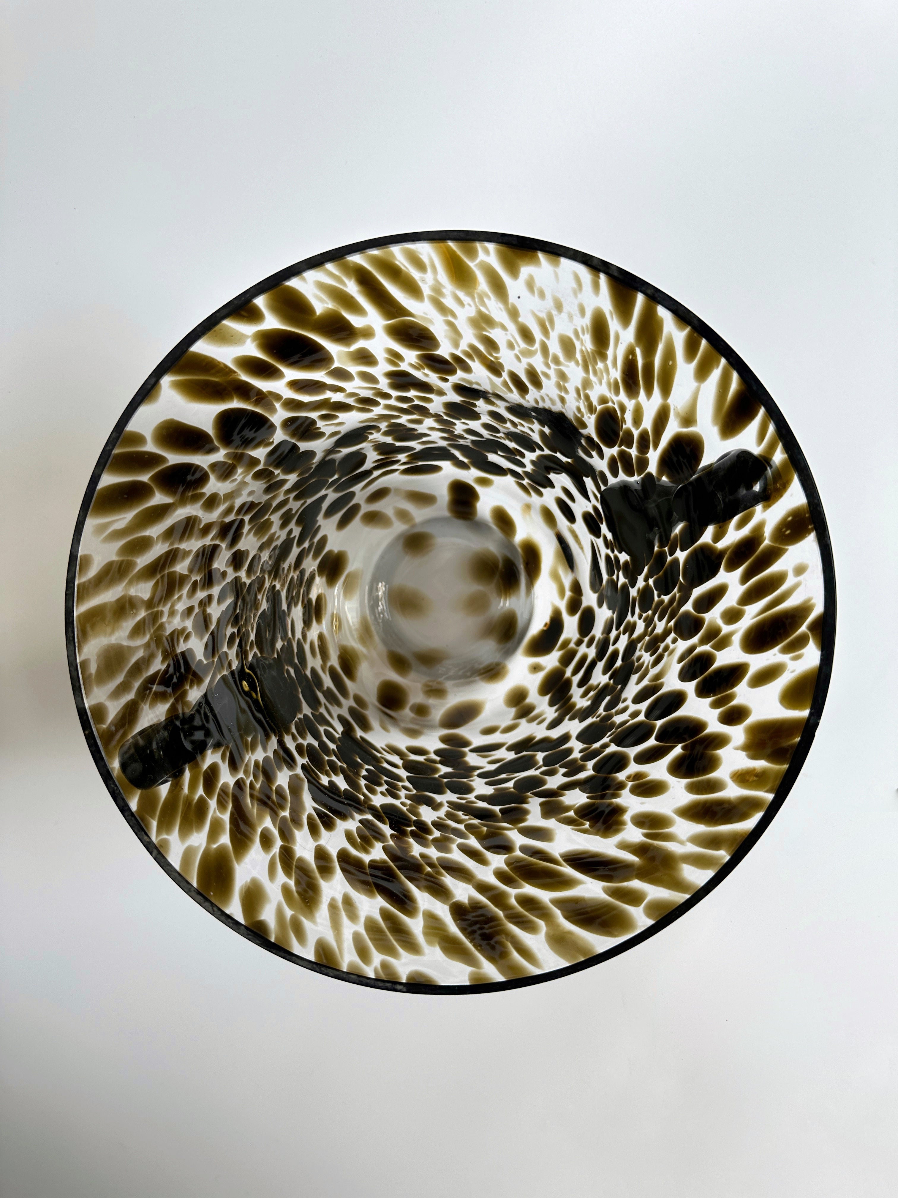 A top-down view of the Art Deco Champagne Bucket / Vase Tortoise Glass by Dodo Vintage showcases its handcrafted Italian design with a white and brown speckled pattern, creating a mesmerizing swirling visual effect. The smooth, glossy finish of the bucket is beautifully highlighted against a plain, light-colored background.