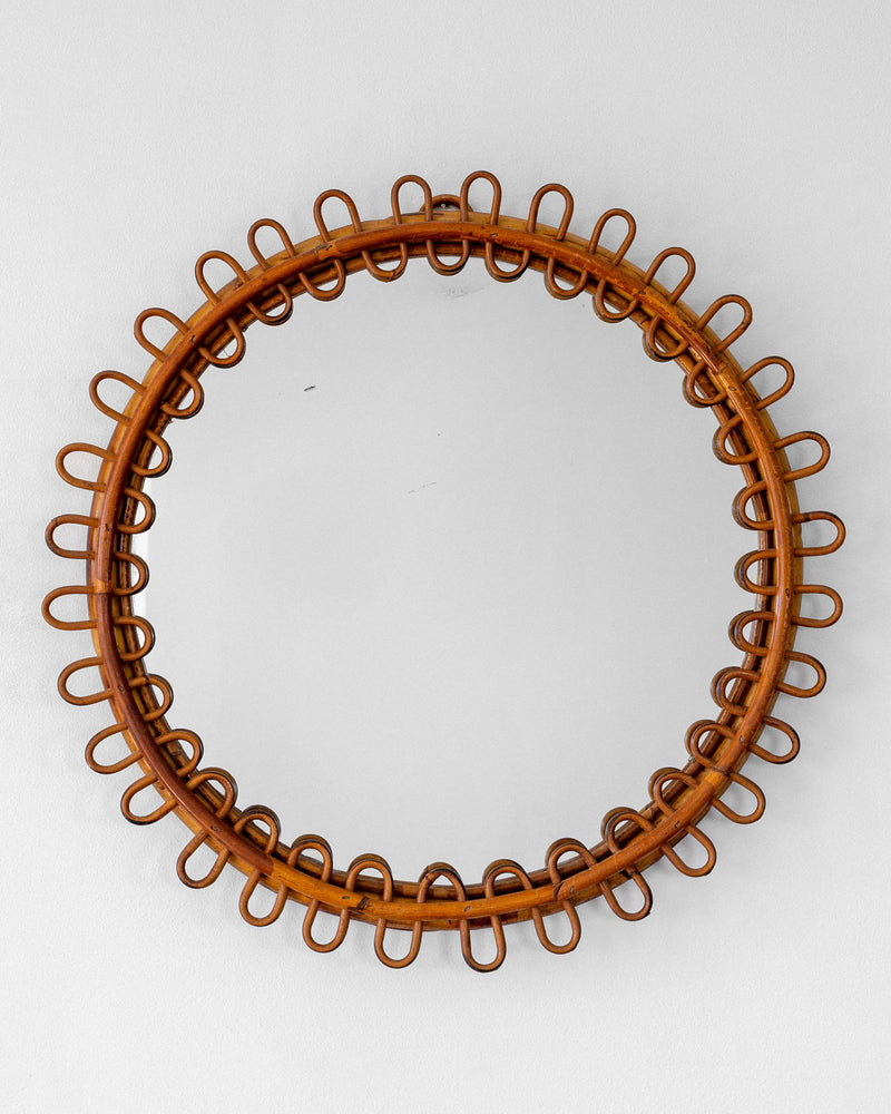 Circular rattan mirror frame with decorative loop border detail