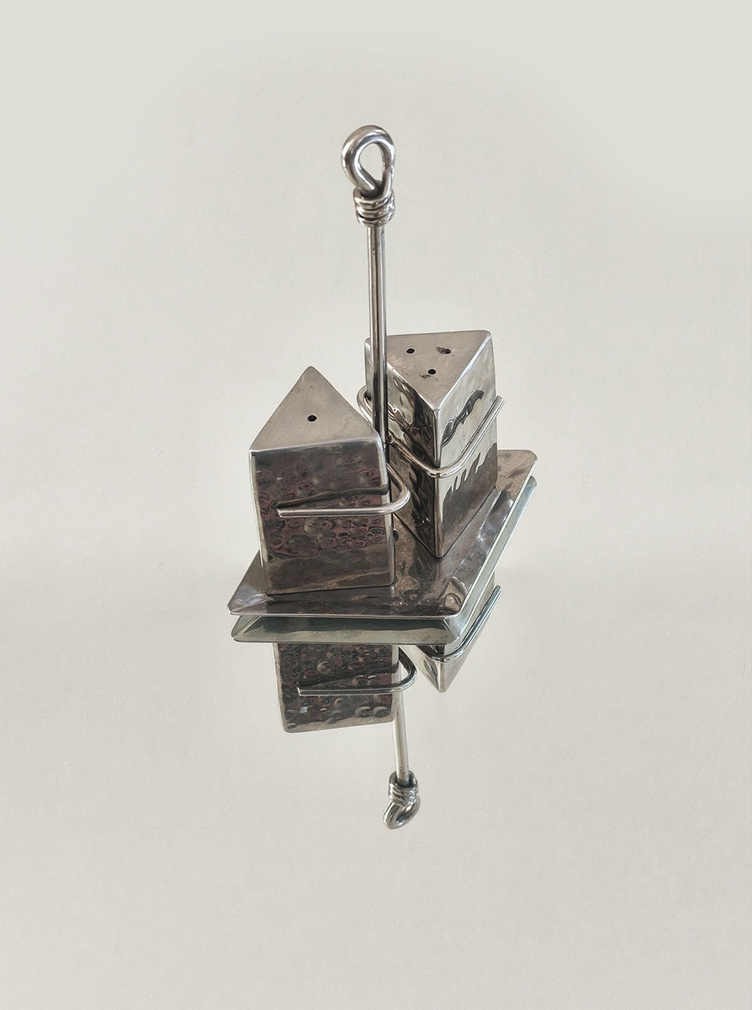 Stainless steel salt and pepper shakers on reflective surface