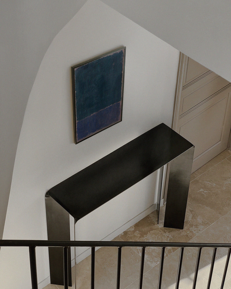 Hiro steel console with black top in modern staircase setting