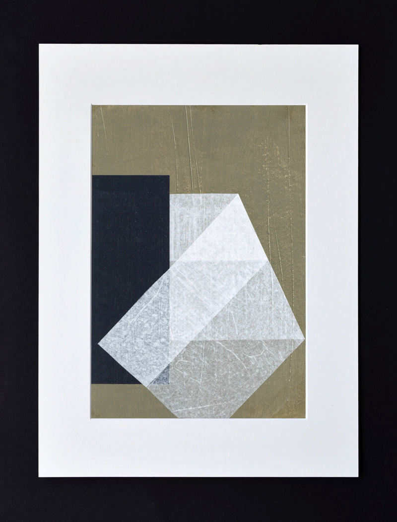 Julita Elbe's "Stone and Gap No.06" art paper collage features abstract geometric shapes in black, white, and gray on handmade cotton paper, highlighting a prominent white faceted shape over a black rectangle on a muted olive background within a white border.