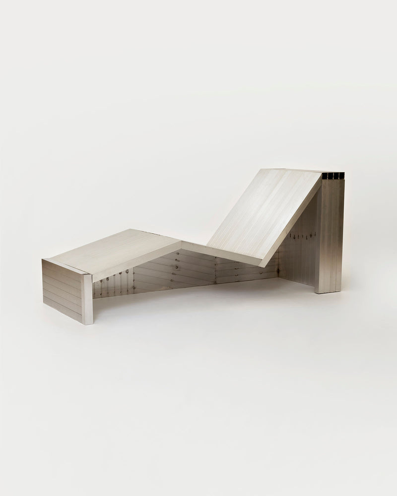 The Aluminum Lounge Chair by Studio HAOS showcases sharp, geometric lines and a minimalist metallic aluminum tube design, exemplifying modern style against a clean white background.