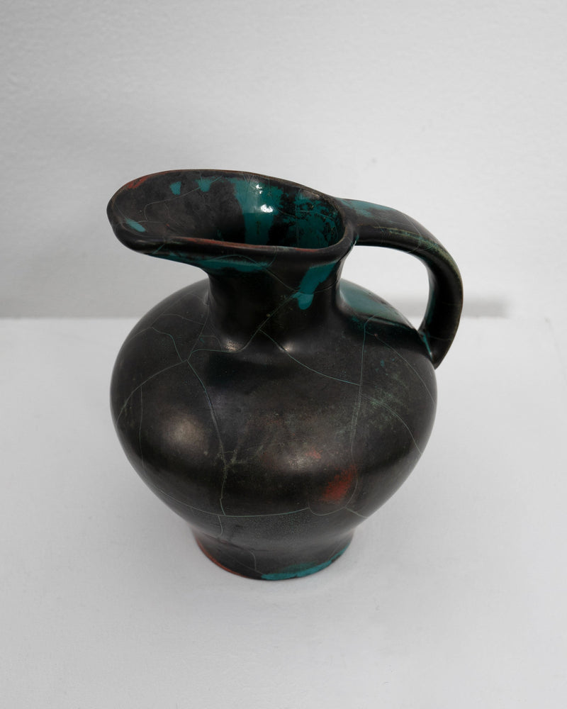 Glazed ceramic jug with dark body and teal accents by Uhlemeyer