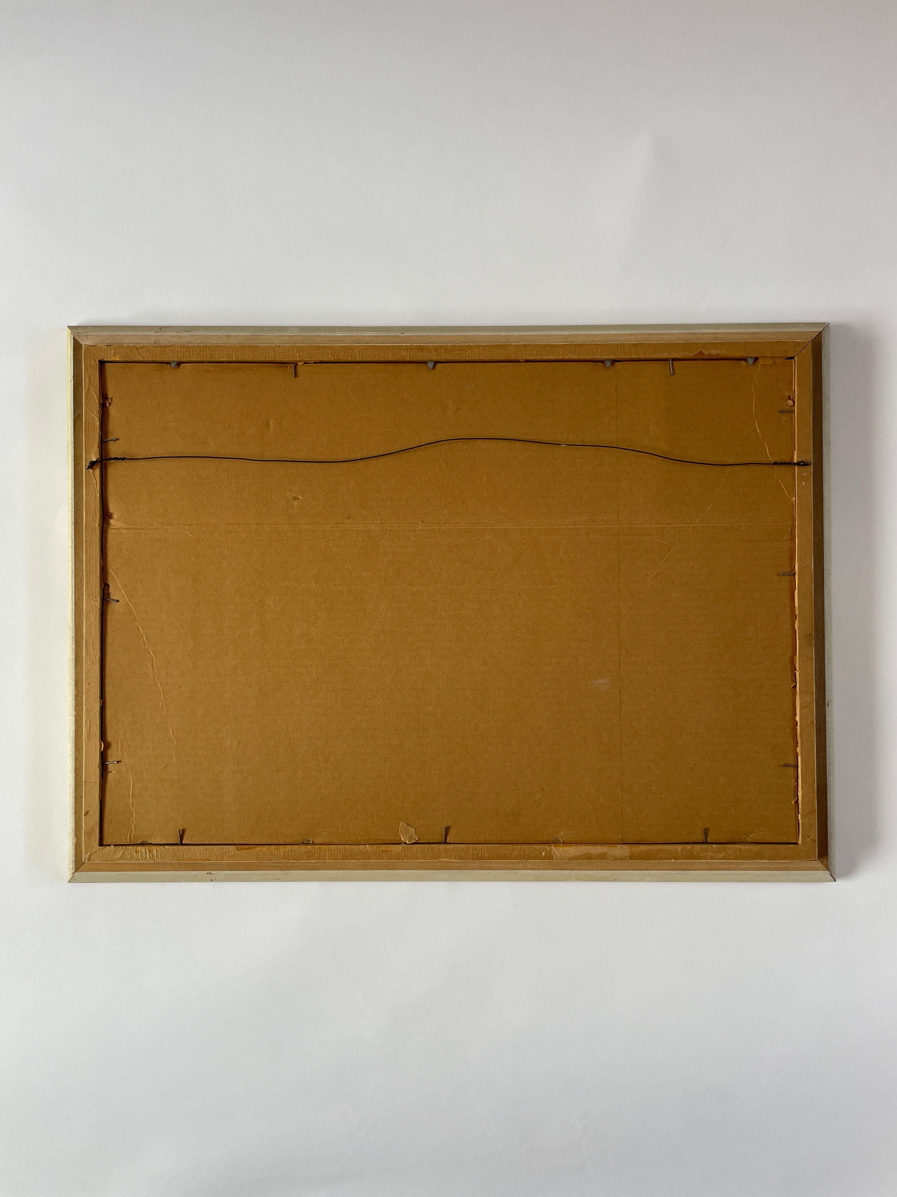 The image displays the back of a rectangular picture frame featuring a cardboard backing and a hanging wire, characteristic of Maud Vaughan's Nude Artwork by LA artist Akop Tashchyan. The frame rests on a flat white surface, embodying the essence of mixed media abstract.