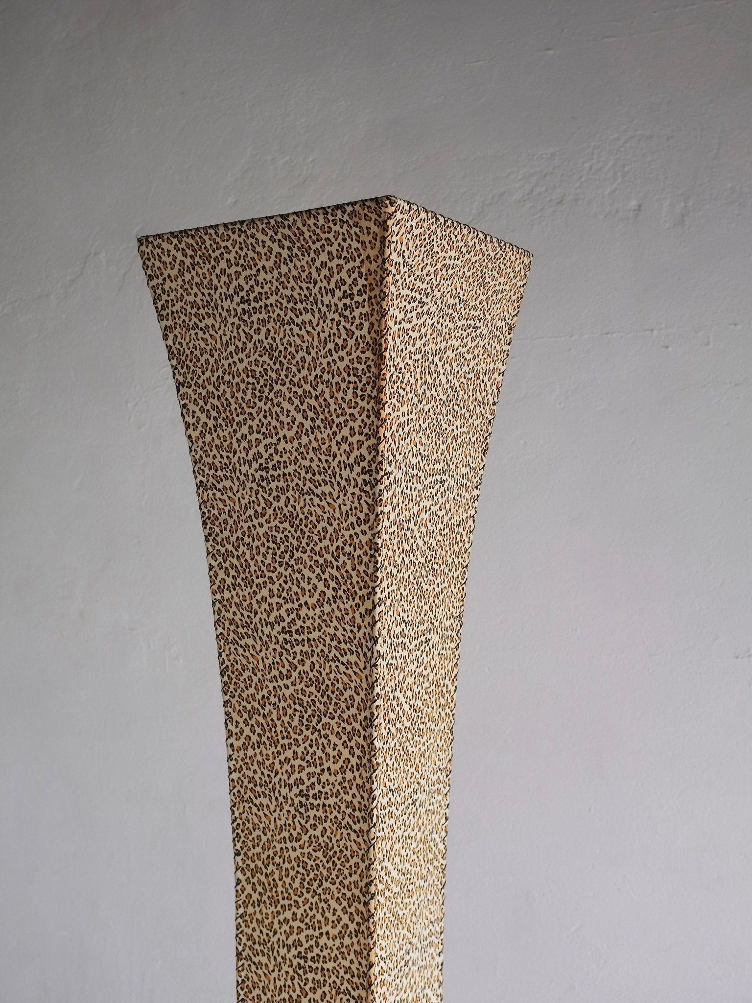 The Veter Vintage Leopard Print Floor Lamp (1980s) is a tall, narrow, four-sided lamp with a flared top and beige-brown leopard pattern, set against a plain light gray wall.