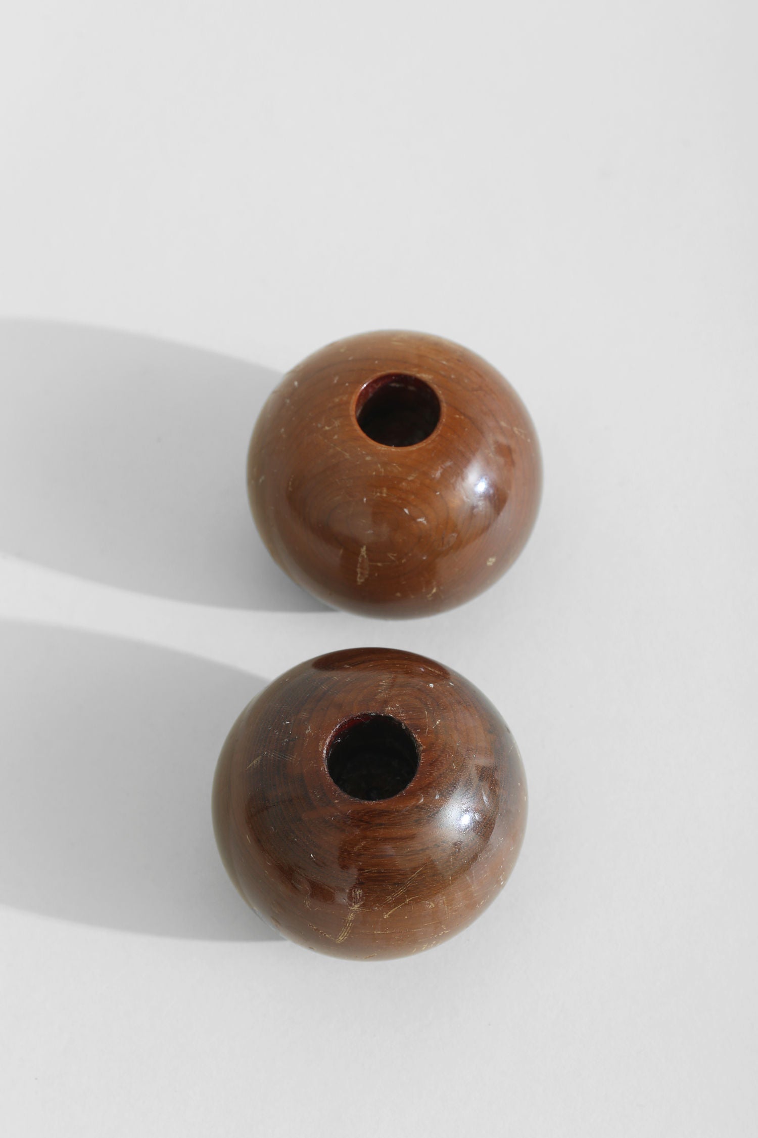 Spherical wood candleholders showing top opening detail
