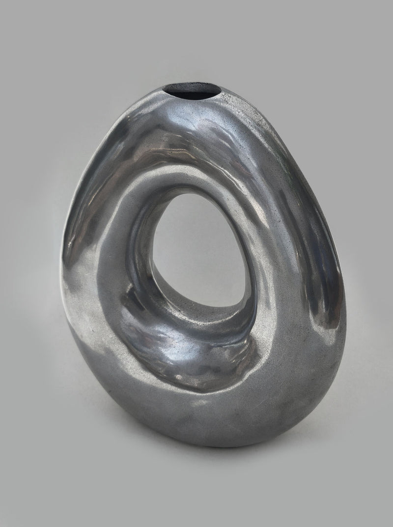 Sculptural metallic circular vase with flowing organic curves