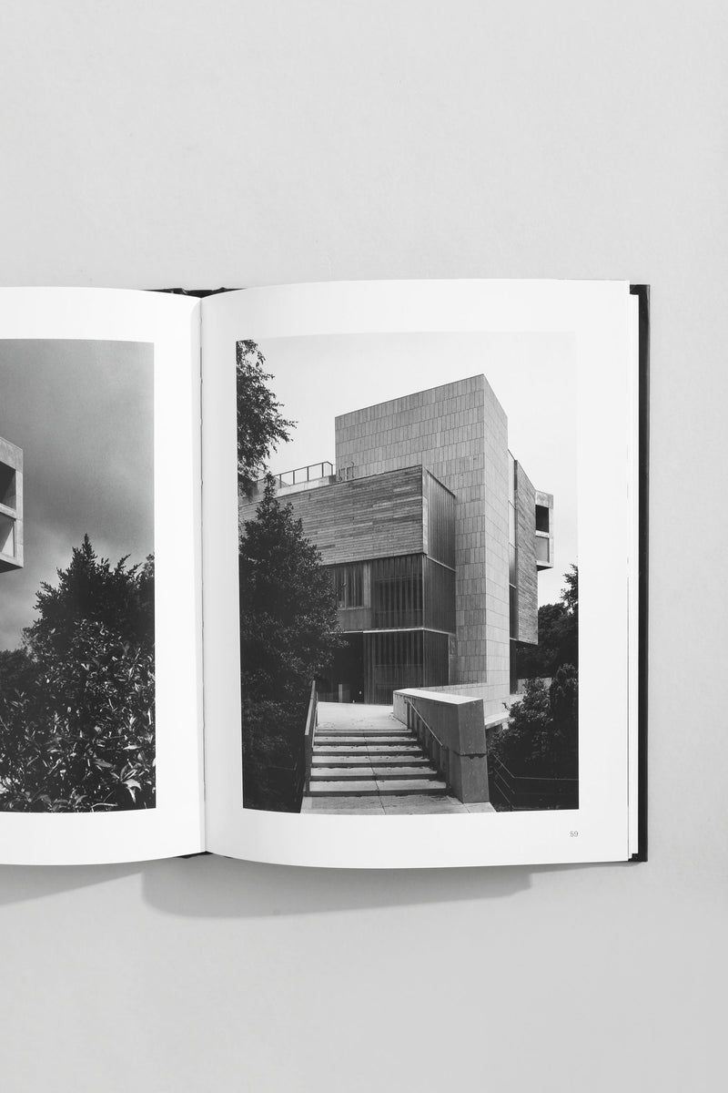 Open architecture book showing modernist concrete building with geometric facades and stone steps
