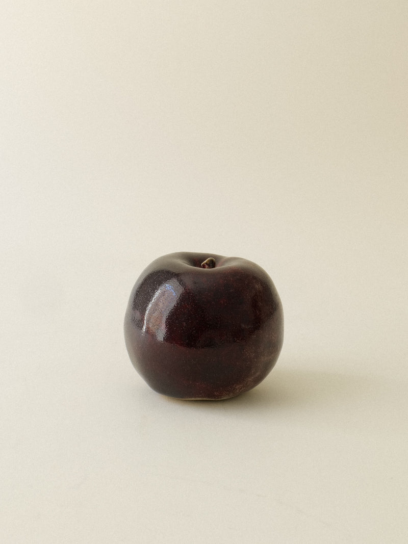 Dark burgundy ceramic apple sculpture with glossy finish