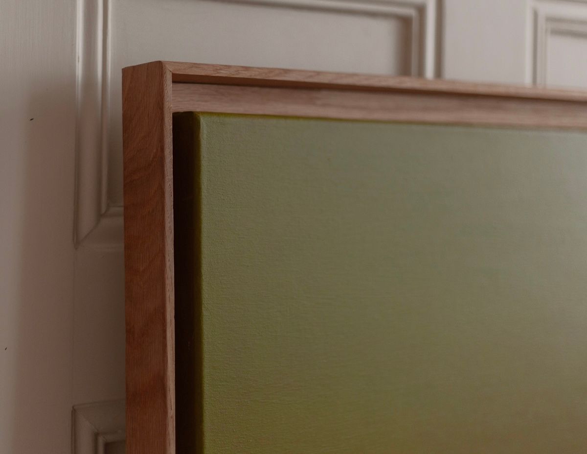 Close-up of a Thru and Thru #2 painting by Rebecca von Matérn, showing the texture of the canvas and wooden frame, leaning against a white paneled door in soft lighting.
