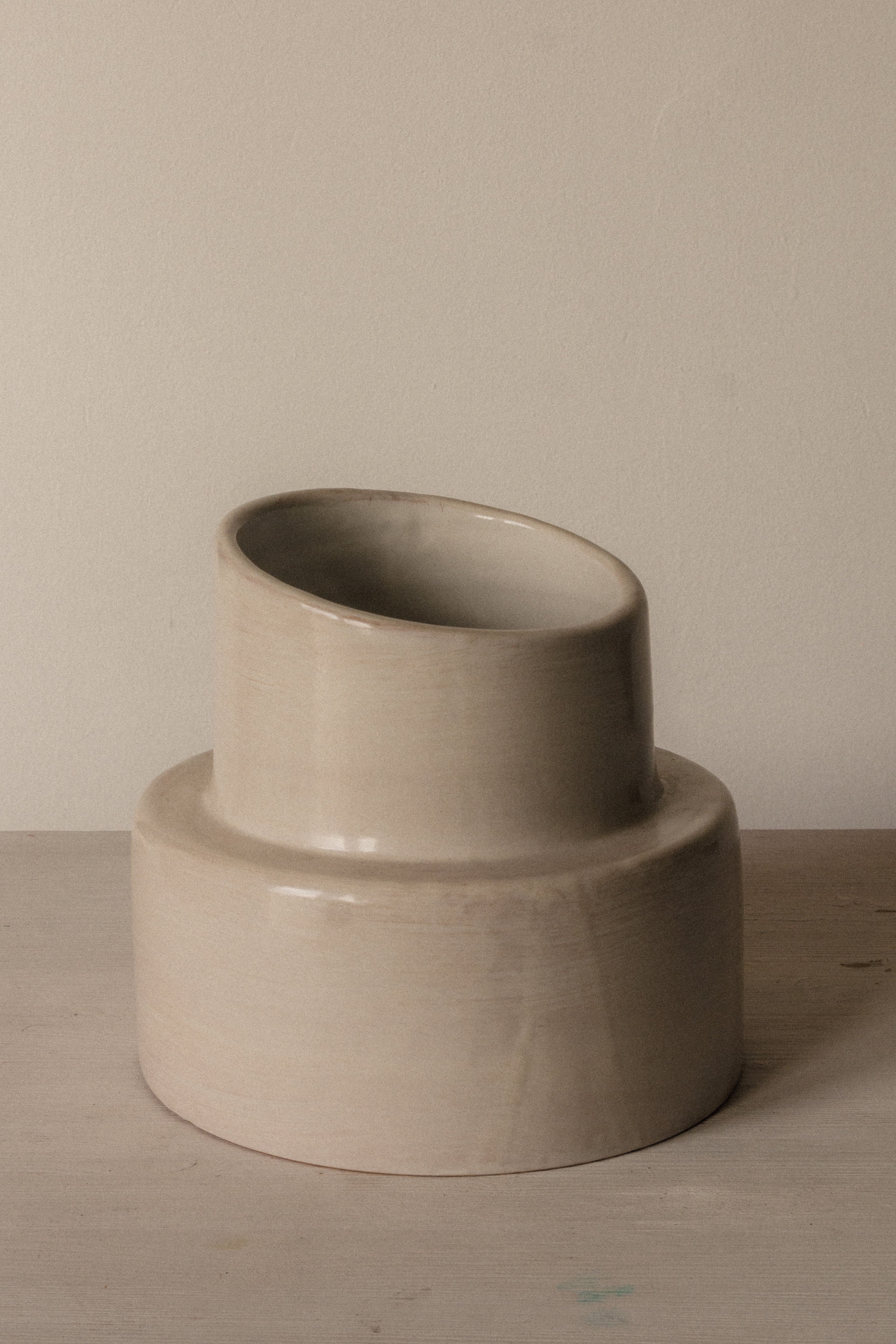 The COSEINCORSO "Pillar" Table Lamp features a beige, cylindrical base inspired by ancient columns, displayed on a light wooden surface against a plain, light background.
