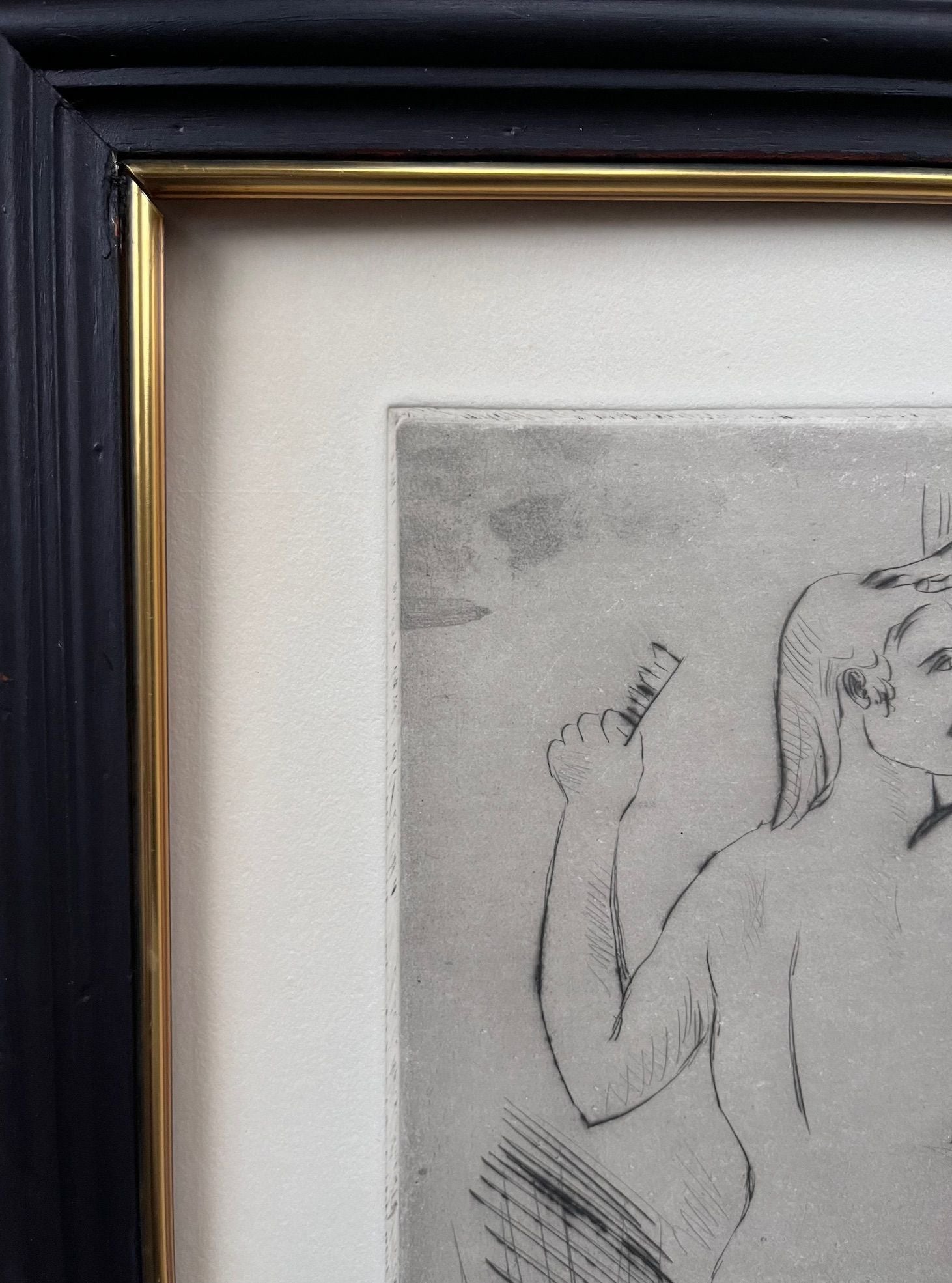 A framed artwork titled "Bathers," a drawing by Josep Busquets Odena under the Médecine brand, showcases a female form with long hair holding an object. The piece, evocative of a Spanish sculptor's craft, partially reveals the upper body and arm and is elegantly set in a gold-edged frame against a light background.