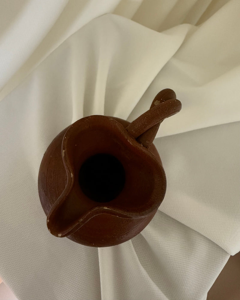 Interior view of small handcrafted ceramic pitcher showing spout