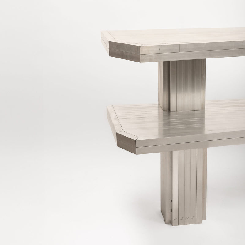 The Aluminum Shelves by Studio HAOS feature modern, geometric design with two offset rectangular tiers and vertical panel legs, showcased against a plain white background.