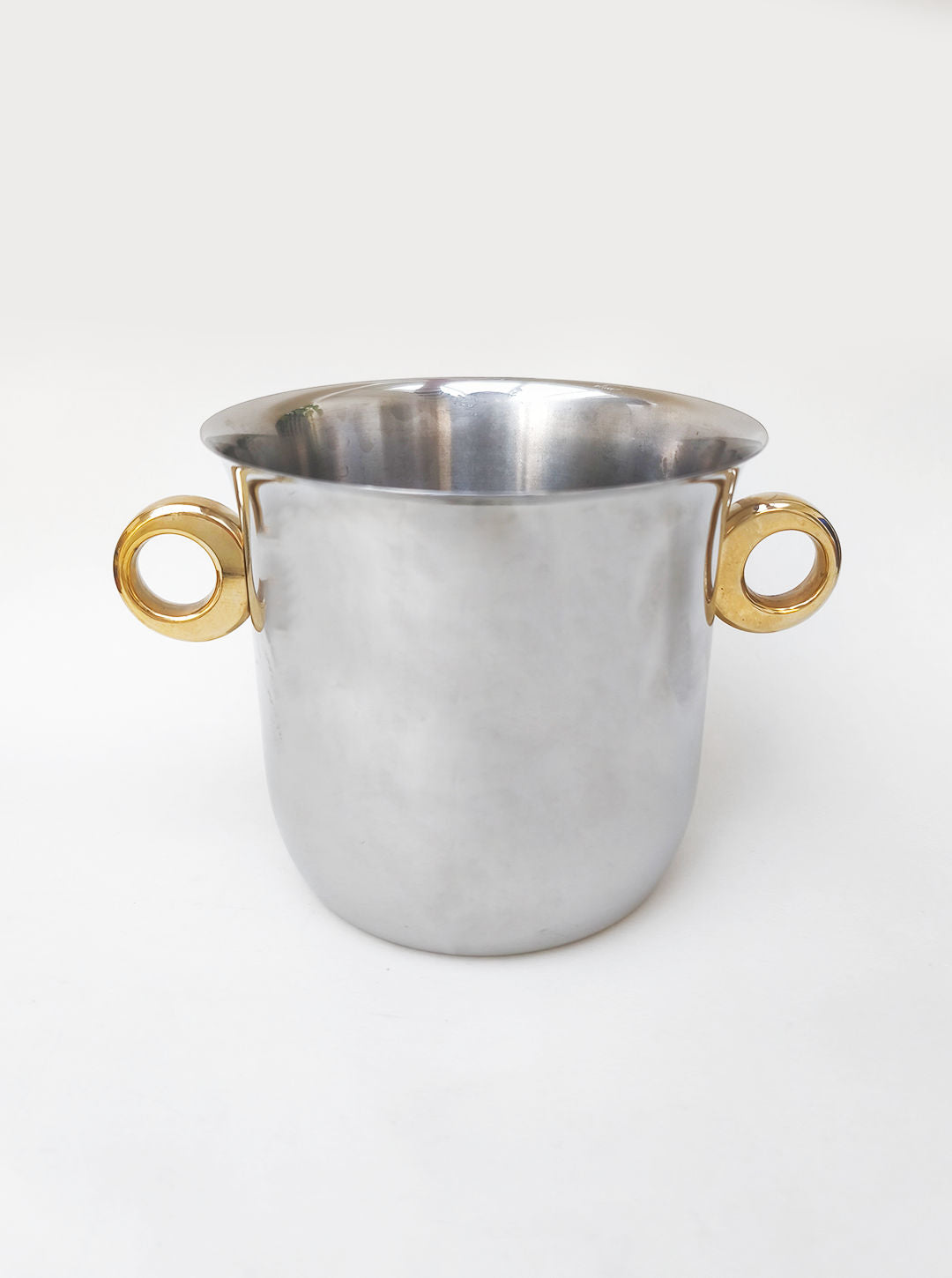 The Les Objoies Ice Bucket, Italy 1970s, showcases Italian modernism in stainless steel with two round brass ring handles, displayed against a plain white background.