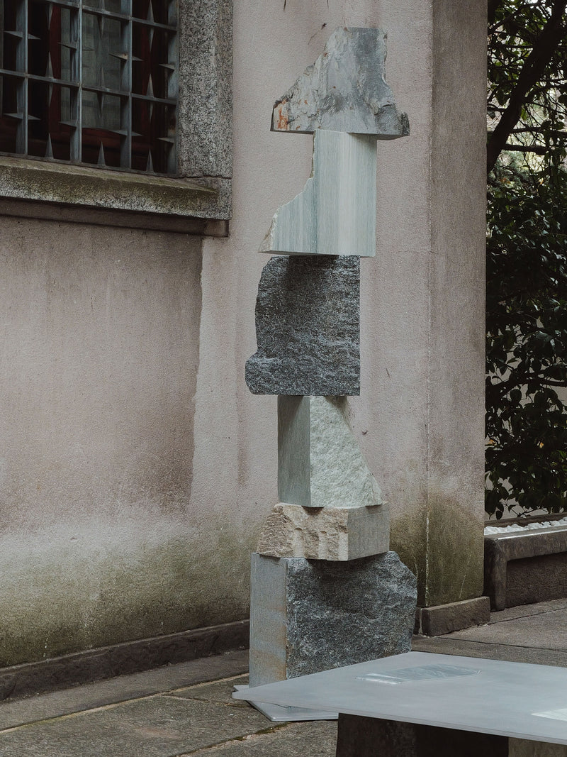 Stacked stone fragments sculpture in contemporary outdoor setting