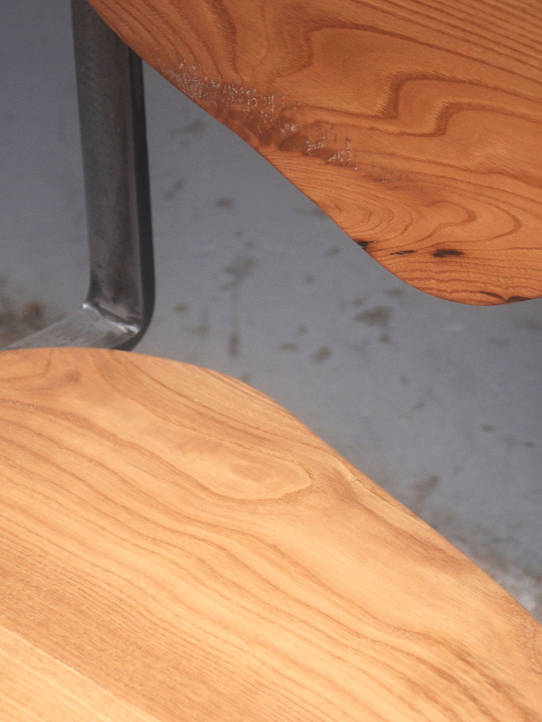 Close-up detail of Carmen chair's curved chestnut wood seat and backrest