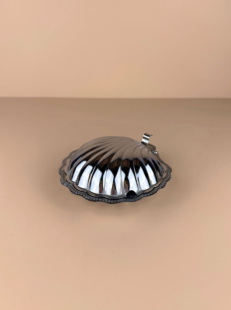  White porcelain butter dish in the shape of a seashell, with delicate patterns