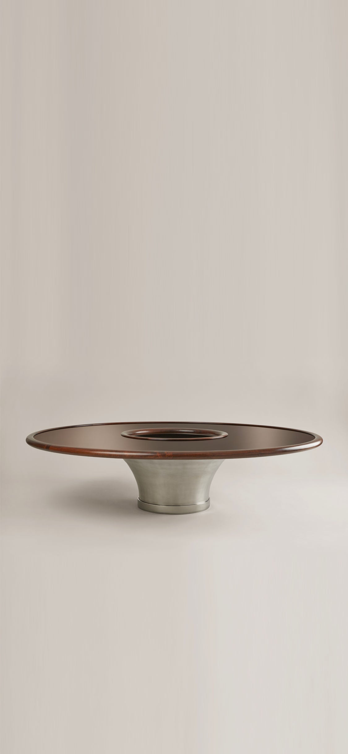 The "Loulou" Coffee Table by HAUVETTE & MADANI features a modern, circular design with a lacquered wood top and a wide, brushed metal base. Its minimalist elegance allows it to seamlessly blend into any neutral background.