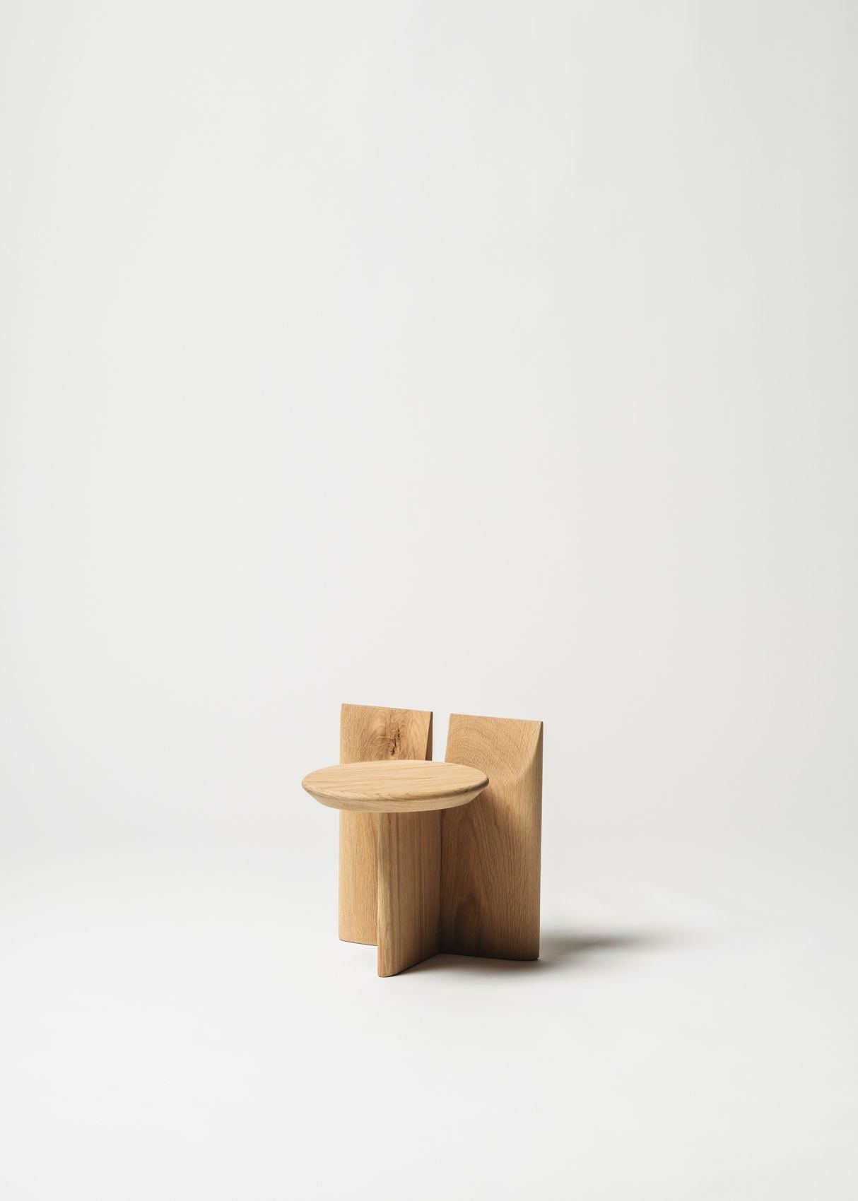 The Tabi Stand by Obstacles is a minimalist wooden stool crafted from natural materials, featuring a round top with a geometric design set against a plain white background.