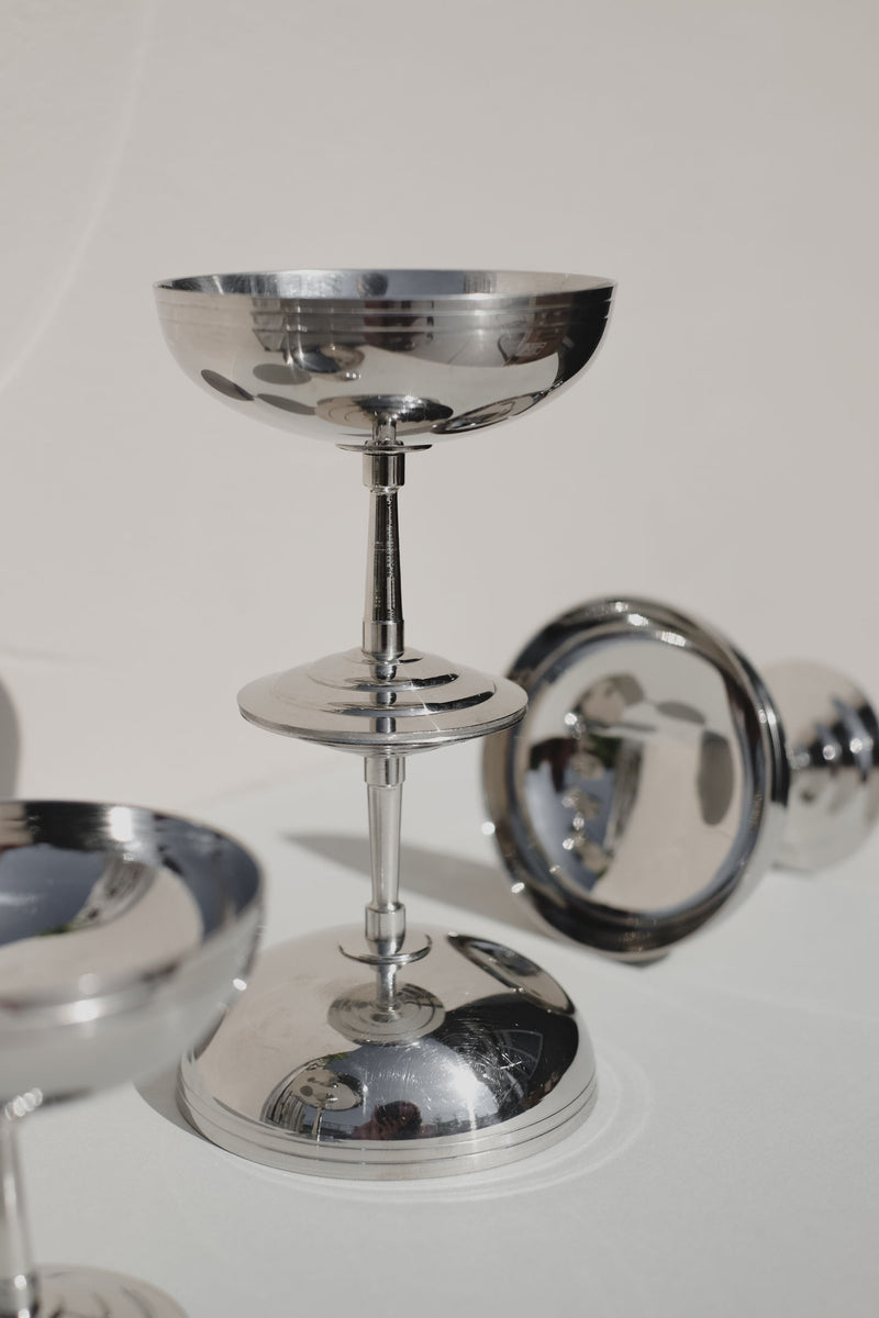Polished silver champagne coupes in elegant serving set