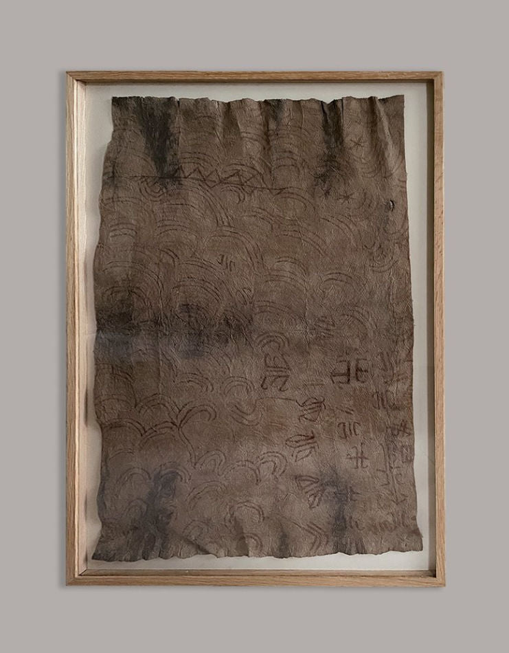 Early Ituri bark cloth painting with carved spiral patterns framed