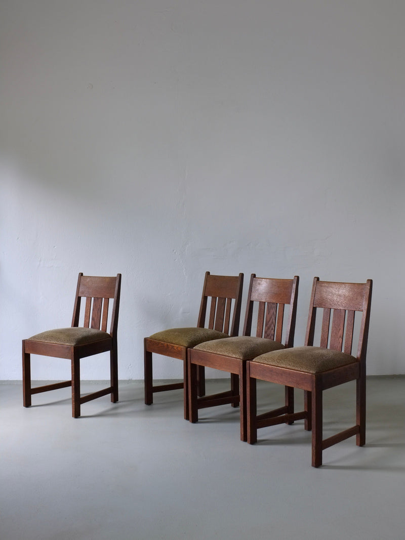 Four Arts & Crafts oak dining chairs with green upholstery, 1910s