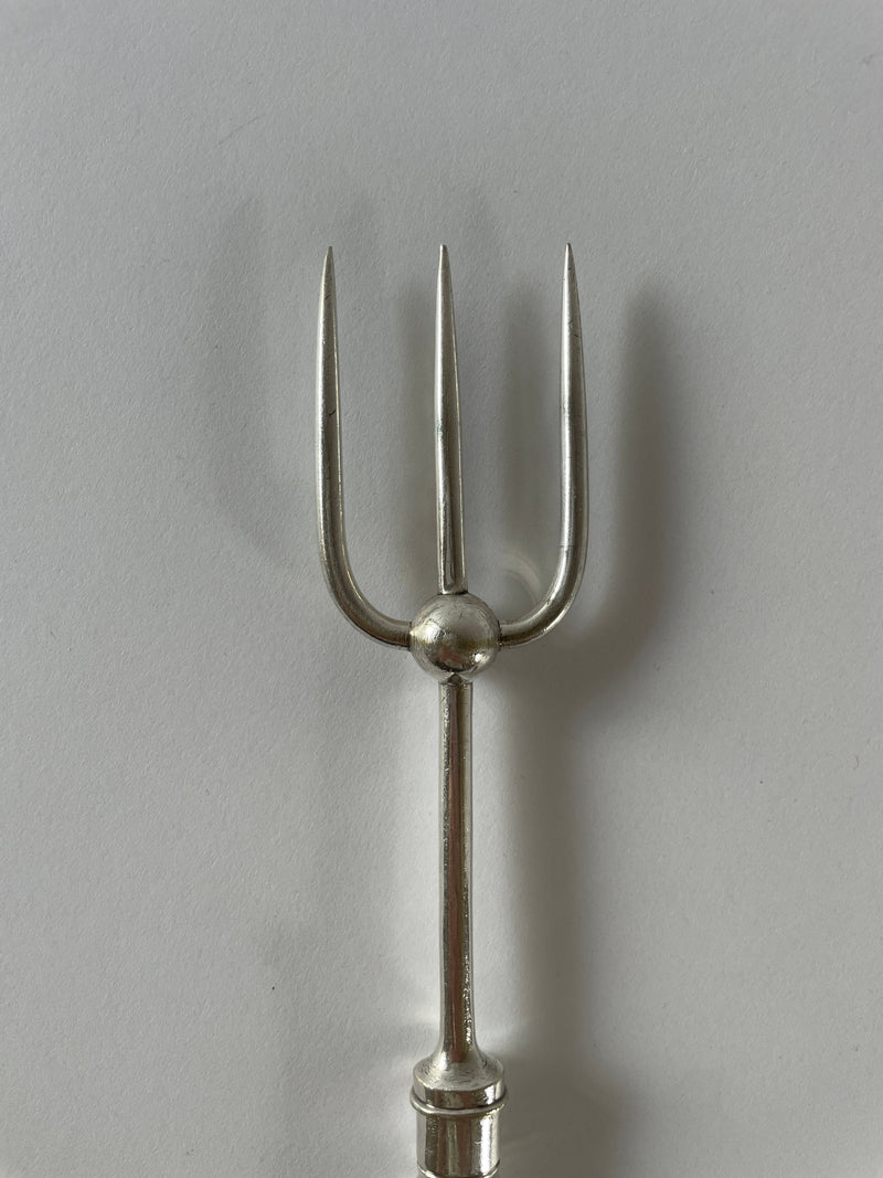 An Antique Silver Plate Serving Fork by Maud Vaughan, featuring three finely crafted prongs, is pictured against a plain white background. The prongs are evenly spaced and the utensil boasts a smooth, reflective surface, evoking the elegance of Victorian etiquette.