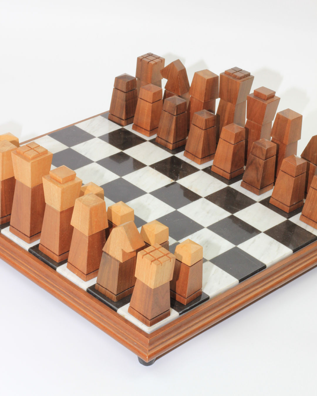 The Wooden and Marble Chessboard from Boga Avante Shop features a contemporary design with abstract, hand-carved wooden pieces set on a stunning checkered black-and-white marble board. Each piece boasts geometric, angular designs, providing an artistic and modern look to the chess set.