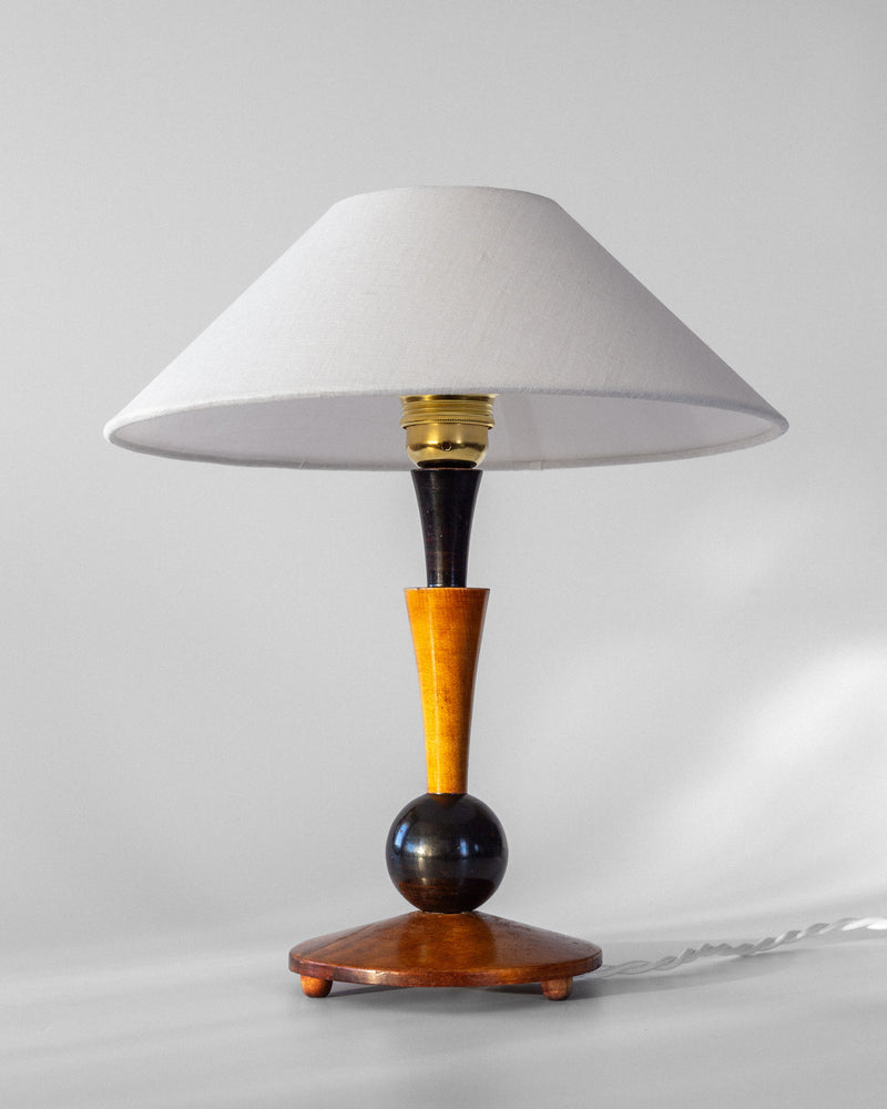 Introducing the Art Deco Wooden Table Lamp by Spigel, a stylish piece featuring a white conical shade and a wooden base with a distinctive spherical black and yellow design. This 1935 handmade creation, set against a light gray background, beautifully exudes vintage character.